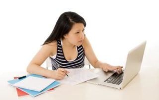 chinese asian woman working on her laptop on white background